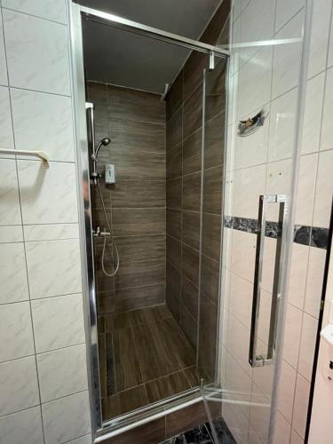 a shower with a glass door in a bathroom at Guest House Luxotel in Zrenjanin