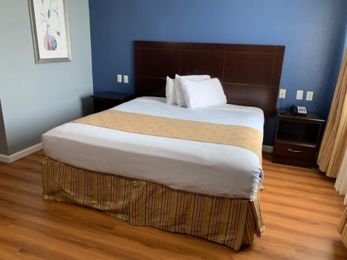 een slaapkamer met een groot bed in een kamer bij Rodeway Inn & Suites Port Arthur - Groves in Port Arthur