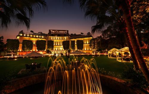 a building with a fountain in front of it at night at The Claridges New Delhi in New Delhi