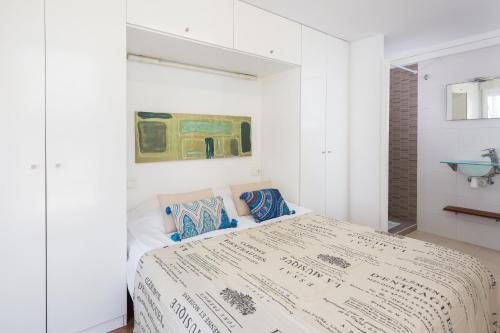 ガンディアにあるVilla Dimarts- a 100m de playaの白いベッドルーム(ベッド1台付)が備わります。壁には絵画が飾られています。