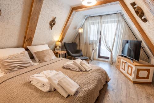 Una habitación de hotel con dos camas y un televisor. en Dom Beskidy, en Brenna