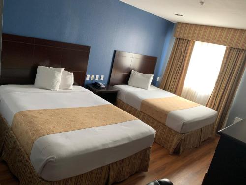 ein Hotelzimmer mit 2 Betten und einem Fenster in der Unterkunft Rodeway Inn & Suites Port Arthur - Groves in Port Arthur