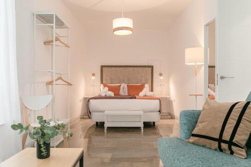 a bedroom with a bed and a blue couch at Indulge en Sevilla Zaragoza in Seville