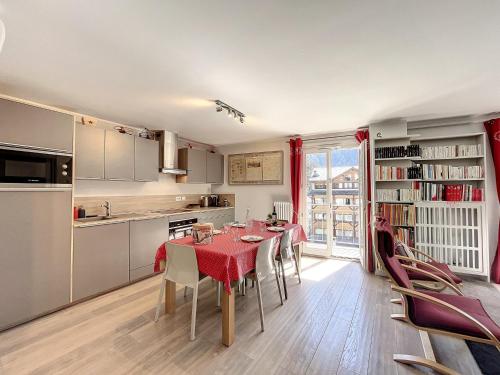 une cuisine et une salle à manger avec une table et des chaises rouges dans l'établissement Chamonix - T2 central, balcon, calme, WIFI, ascenseur - FR-1-507-37, à Chamonix-Mont-Blanc