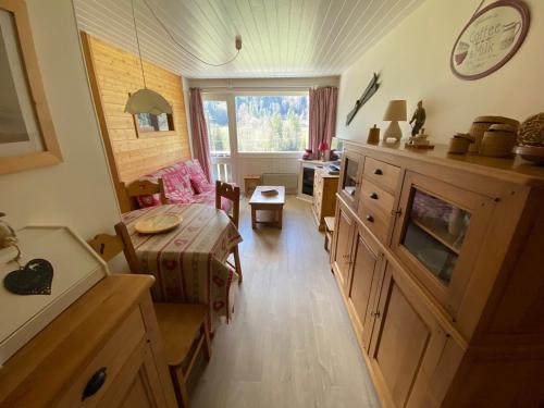une pièce avec un salon avec une table et une table dans l'établissement Charmant 2 pièces avec balcon - Multi Pass 3€/jour/personne - FR-1-692-36, à La Chapelle-dʼAbondance