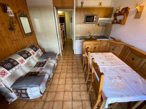 une cuisine avec une table et des chaises dans une pièce dans l'établissement Appartement avec Terrasse, Balcon Sud et Garage à La Chapelle-d'Abondance - FR-1-692-59, à La Chapelle-dʼAbondance