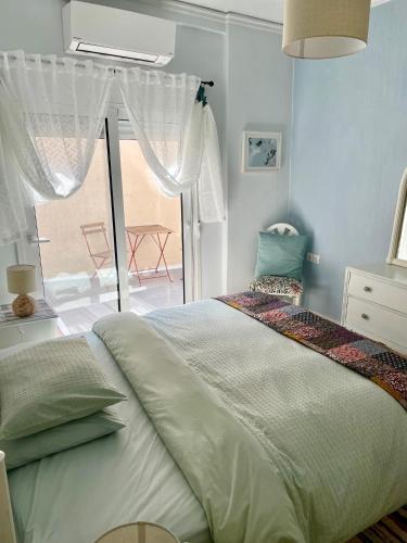 a bedroom with a bed and a large window at Socratous House in Salamís