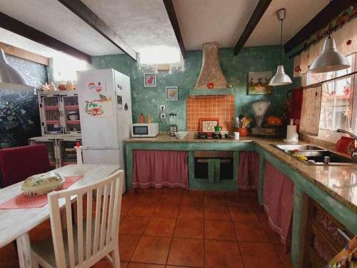 cocina con paredes verdes y nevera blanca en La Bodeguita Apartamento Santo Domingo, en La Guancha