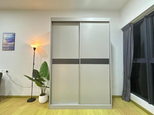 een glazen schuifdeur in een kamer met een plant bij Danga Bay 4pax Highest floor Nice View in Johor Bahru