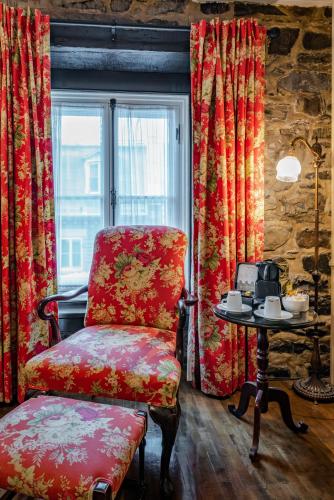 a chair and a table in a room with a window at Le Clos Saint-Louis in Quebec City