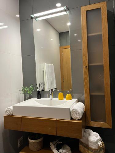 a bathroom with a large white sink and a mirror at Crystal House in Angra do Heroísmo