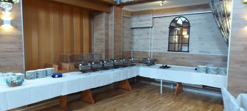 a room with a long table with white plates on it at Hotel Restaurant Hellas in Gelting