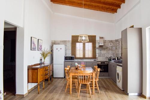 uma cozinha com uma mesa e cadeiras e um frigorífico em Galatia's House em Kouklia