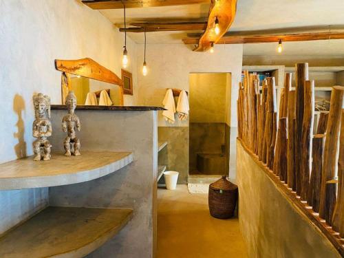 a room with a table and some wooden logs at CAJOU LODGE in Bubaque