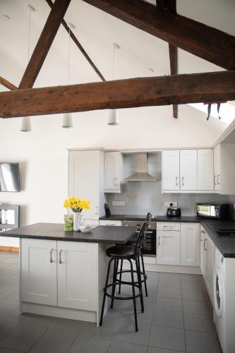 a kitchen with white cabinets and a black counter top at 1 Beacon View Barn in Felindre