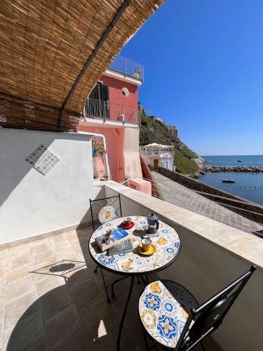 a table and chairs on a balcony with a view of the ocean at Calilla house by Procida Reserve in Procida