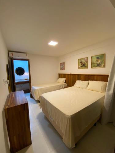 a bedroom with two beds and a window at Vilage Villa Andorinha - apt 09 in Mucugê