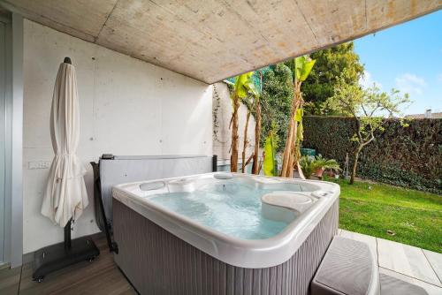 eine große Badewanne im Hinterhof mit Sonnenschirm in der Unterkunft Villa Alvarium 2 in Schenna