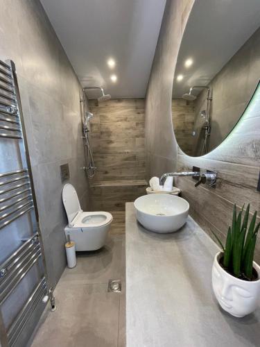a bathroom with a toilet and a sink and a mirror at Breathtaking View design apartment in Katerini