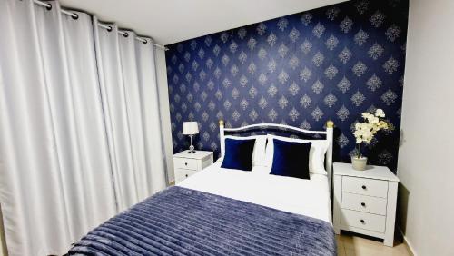 a bedroom with a bed and a blue wall at kelly's House Plateau City Center in Praia