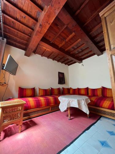 un soggiorno con divani rossi e un tavolo di zazou a Essaouira