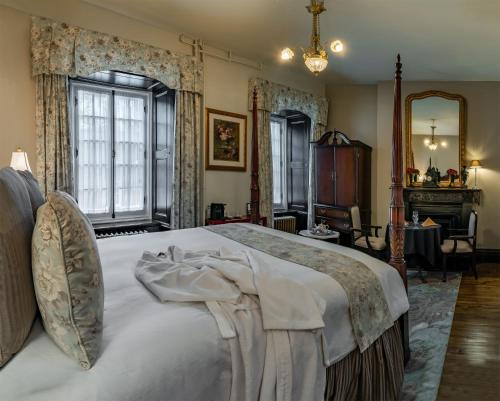 a bedroom with a large white bed with a mirror at Le Clos Saint-Louis in Quebec City