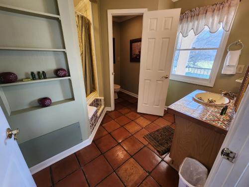 a bathroom with a sink and a toilet and a window at Williams Island Room at Tennessee RiverPlace in Chattanooga