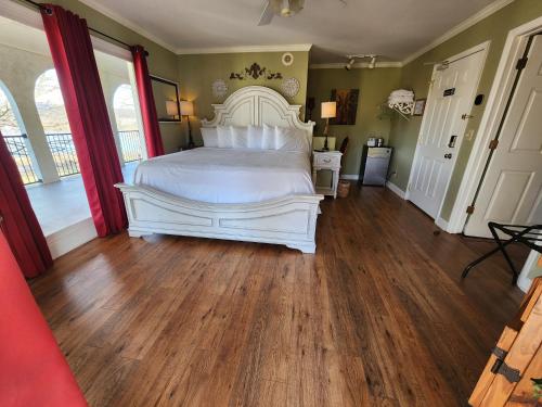 a bedroom with a white bed and wooden floors at Williams Island Room at Tennessee RiverPlace in Chattanooga