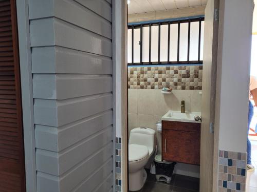 a bathroom with a toilet and a sink at Cabañas y Restaurante Miss Elma in Providencia