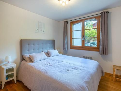 une chambre avec un grand lit et une fenêtre dans l'établissement Appartement cosy, 2 chambres avec terrasse, proche pistes de ski, WIFI - La Clusaz - FR-1-437-86, à La Clusaz