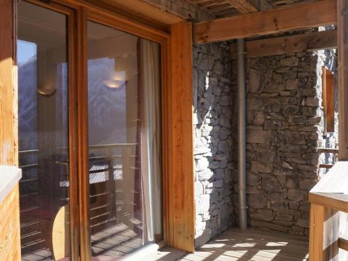 une porte coulissante en verre sur une maison en pierre dans l'établissement Appartement cosy 2 pièces, 4 pers, balcon, parking, WIFI, Orcières Merlette - FR-1-636-140, à Orcières