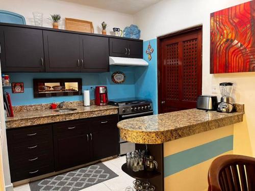 una cucina con armadi neri e piano di lavoro di Playakaan21 by Utopia a Playa del Carmen