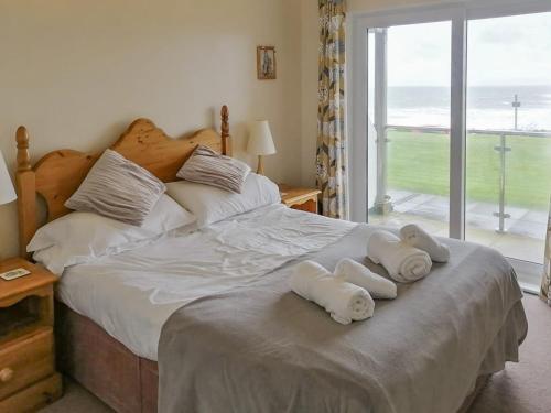a bedroom with a bed with towels on it at Apartment 1 Waterrs Edge in Crantock