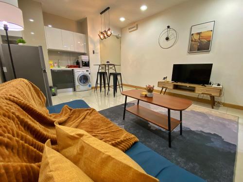 a living room with a blue couch and a table at Lily and Loft - KL Gateway Bangsar LRT, WIFI, Netflix in Kuala Lumpur