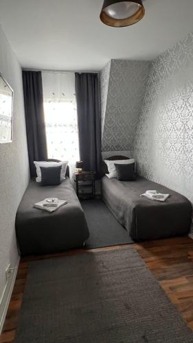 a bedroom with two beds and a window at Pension Chevermeto in Chemnitz