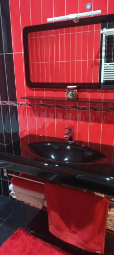 a red bathroom with a black sink and red towels at Casa Pepe in Meaño