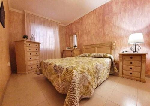 a bedroom with a bed and two dressers and a lamp at Apartamento Vista Atlántico in Adeje