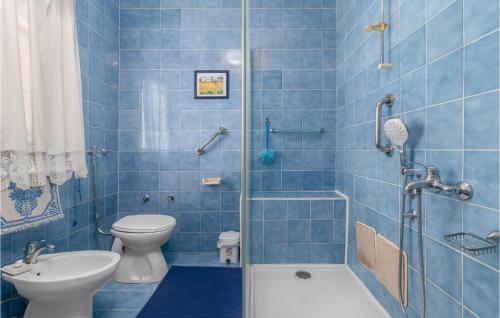 Pet Friendly Apartment In Kostrena With Kitchen في كوسترينا: حمام من البلاط الأزرق مع مرحاض ودش