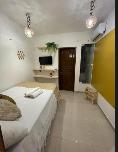 a bedroom with a bed and a tv and a room at Residencial Temporada Aracaju in Aracaju