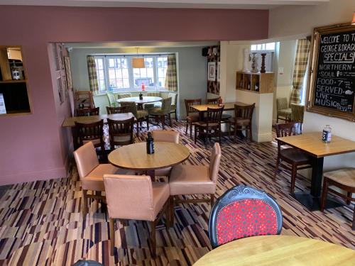 a dining room with tables and chairs and a restaurant at George and Dragon in Tarvin