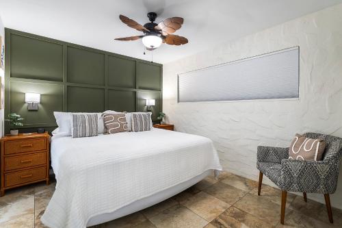 a bedroom with a white bed and a ceiling fan at Casa De Emdeko 104 in Kailua-Kona