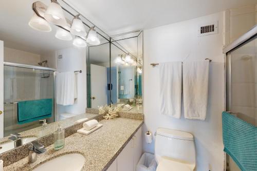 a bathroom with a toilet and a sink and a mirror at Decoplage Paradise - Unit A in Miami Beach