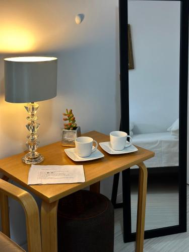 a wooden table with two cups and a lamp on it at Pensjonat Jagoda B&B in Międzyzdroje
