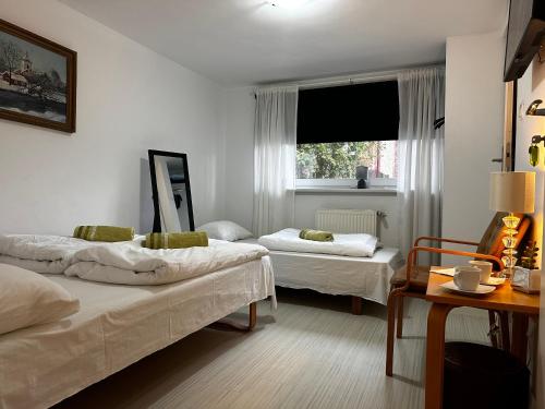 ミエンジズドロイェにあるPensjonat Jagoda B&Bのベッド2台と窓が備わる客室です。