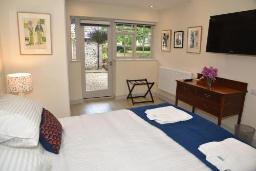 a bedroom with a bed and a dresser and a television at The Mill B&B in Thetford