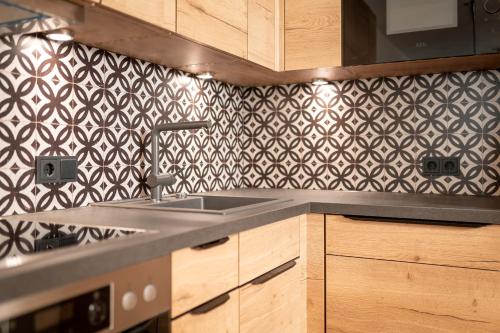 a kitchen with a sink and a black and white wallpaper at Wildbach Lodge Dienten in Dienten am Hochkönig