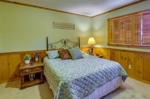 1 dormitorio con 1 cama y 1 mesa con lámpara en Cozy Moneta Getaway Near Smith Mountain Lake!, en Moneta
