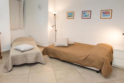 a bedroom with two beds with blankets and a lamp at A22 - Ancona, delizioso monolocale in pieno centro dx in Ancona