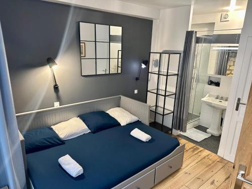 a bedroom with a blue bed and a bathroom at Home Sweet Home Le Chapelais Montmartre in Paris