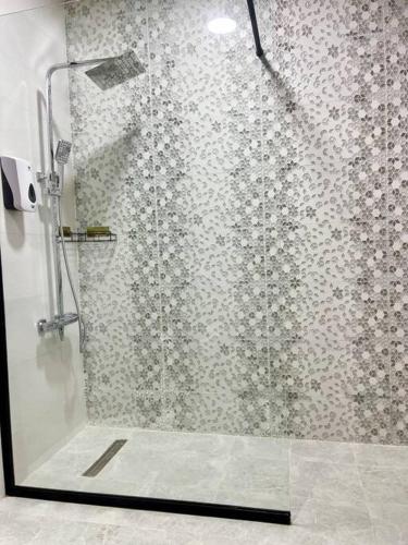 a shower with a glass door in a bathroom at Lovely Private Contemporary Residential Apartment - 201 in Abu Dhabi